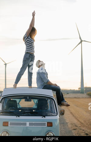 Happy couple on roof of a camper van in rural landscape Stock Photo - Alamy