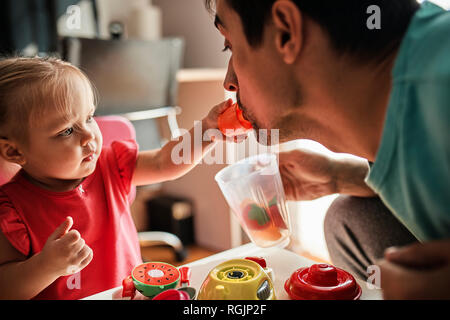 Little girl playing together with her father at home Stock Photo