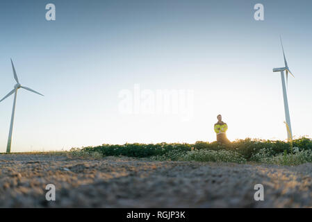 Engineer standing in a field at a wind farm Stock Photo