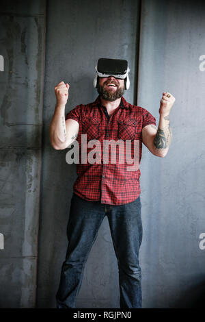 Happy bearded man wearing VR glasses Stock Photo