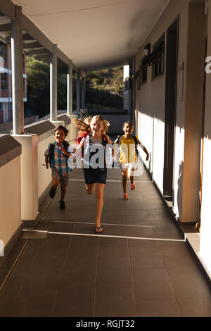 Schoolkids with schoolbags running in hallway Stock Photo
