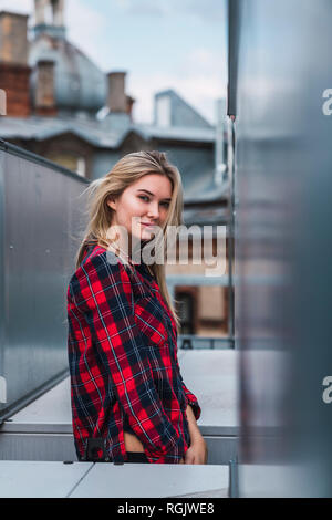 Portrait of smiling blond young woman wearing plaid shirt Stock Photo
