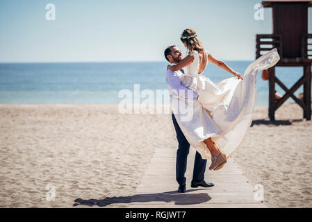 Happy bridal couple enjoying their wedding day on the beach Stock Photo