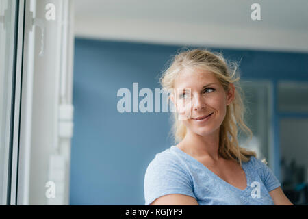 Portrait of smiling blond woman looking sideways Stock Photo