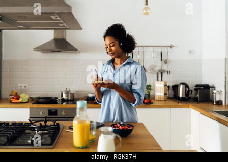 Woman in her kitchen in the morning, writing notes Stock Photo