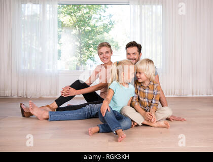 Relaxed family sitting on the floor at home Stock Photo
