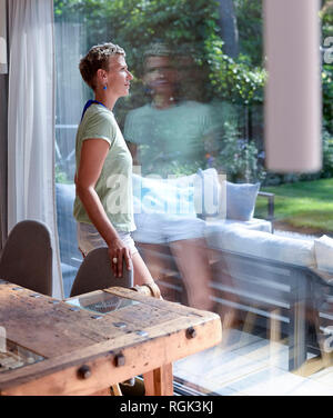 Woman looking out of window Stock Photo
