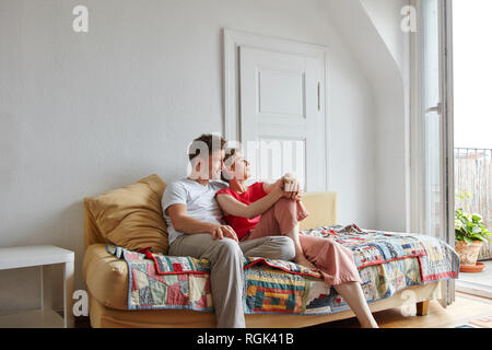 Relaxed couple sitting on couch at home Stock Photo