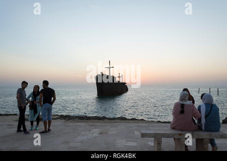 Kish island, IRAN - October 31, 2015  People visiting and taking photos with greek ship wreckage in kish island after sunset Stock Photo