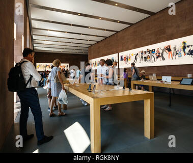 PARIS, FRANCE - JUL 16, 2018: Modern Apple Mac store main hall with customers buying latest Apple computers gadgets and objects Stock Photo