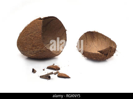 Still life with empty broken coconut shell and smithers isolated on white background. Horizontal close-up photo Stock Photo