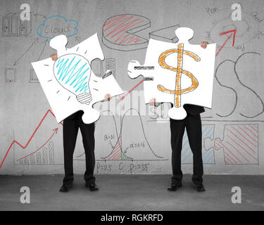 Idea is money concept on puzzles with men holding in office Stock Photo