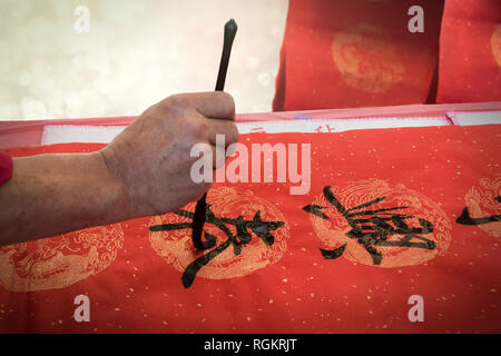 Chinese calligraphy writing Happy New Year on red paper. Stock Photo