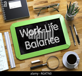 Work-Life Balance Handwritten on Green Small Chalkboard. Top View of Wooden Office Desk with a Lot of Business and Office Supplies on It. Small Chalkb Stock Photo