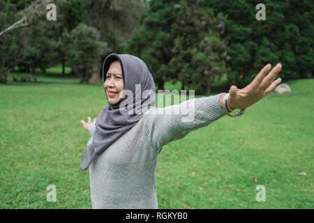 enior muslim woman relaxing taking deep breath and stretching Stock Photo