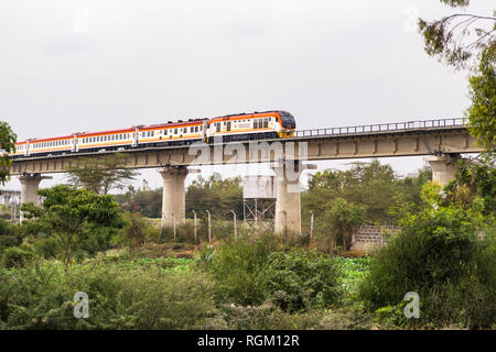 The Madaraka Express Passenger Service train travelling on a viaduct section of the Nairobi to Mombasa Standard Gauge Railway SGR, Athi River, Kenya Stock Photo