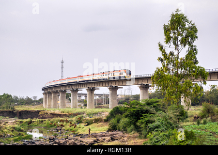 The Madaraka Express Passenger Service train travelling on a viaduct section of the Nairobi to Mombasa Standard Gauge Railway SGR, Athi River, Kenya Stock Photo