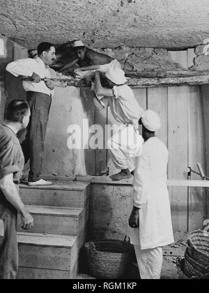 Howard Carter who discovered Tutankhamun's Tomb in the Valley of the Kings, Luxor, Egypt. November 1922. Carter using a pry bar inside the tomb. Scanned from image material in the archives of Press Portrait Service (formerly Press Portrait Bureau) Stock Photo