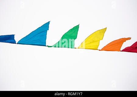 Colorful multicolored triangular flags, isolated on a white background, hang on a rope and flutter in the wind. Holiday decoration, carnival, festival Stock Photo