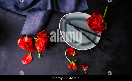 Summer table setting decorated with Red Princess tulips on rustic background Stock Photo