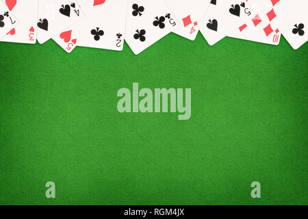 Cards on green felt casino table background. Template with copy space in center Stock Photo