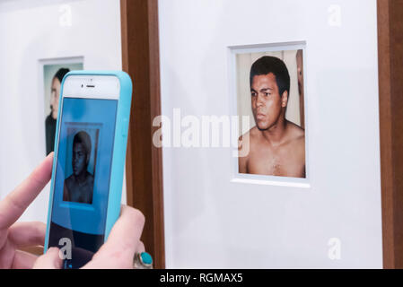 London, UK.  30 January 2019. A visitor photographs 'Muhammad Ali' (1977). Preview of 'Andy Warhol Polaroid Pictures', an exhibition of over 60 portrait and self-portrait Polaroid photographs by Andy Warhol.  The works, which depict artists, actors, politicians and friends of his Factory entourage in New York during the 1970s and 80s, are on display 2 February to 13 April 2019 at Bastian Gallery in Mayfair.  Credit: Stephen Chung / Alamy Live News Stock Photo