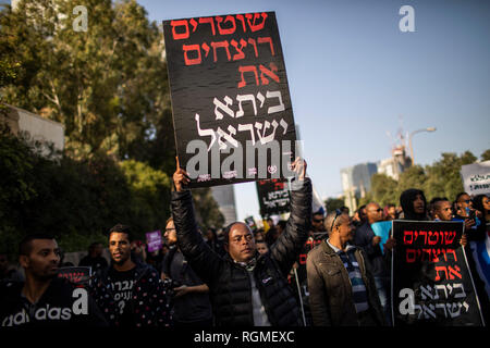 Tel Aviv, Israel. 30th Jan, 2019. An Ethiopian-Israeli man holds a placard during a protest against alleged police brutality. The protest comes after the police shot dead 24-year-old Ethiopian man Yehuda Biadga in the Israeli city of Bat Yam earlier in January, an incident described by the police as 'a life-threatening situation' after Biadga ran toward officers with a knife. Credit: Ilia Yefimovich/dpa/Alamy Live News Stock Photo