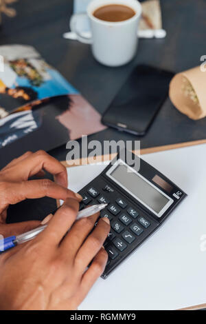 Hand of a woman using calculator Stock Photo