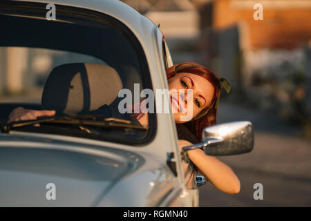 Young woman driving vintage car in summer, smiling Stock Photo