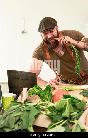 Mature man trying out vegetarian online-recipes Stock Photo
