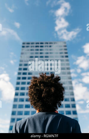 Spain, Barcelona, rear view of a young businessman looking at office block in the city Stock Photo