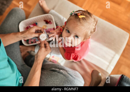 Portrait of little girl playing together with her father at home Stock Photo
