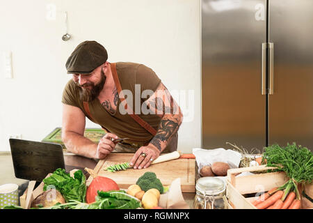 Mature man trying out vegetarian online-recipes Stock Photo