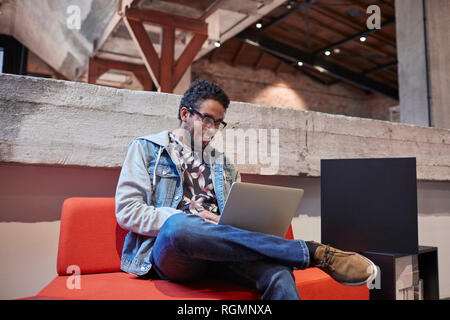 Young man working in creative start-up company, using laptop Stock Photo