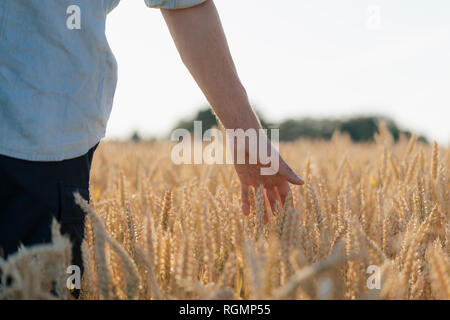 Close-up of man in a field touching ears Stock Photo