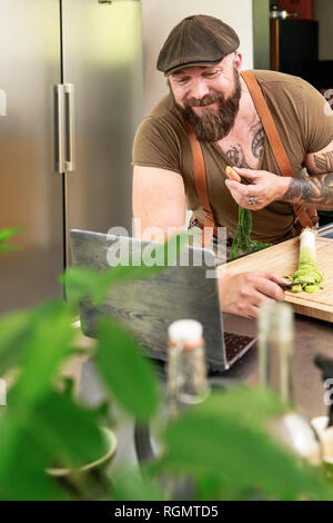 Mature man trying out vegetarian online-recipes Stock Photo