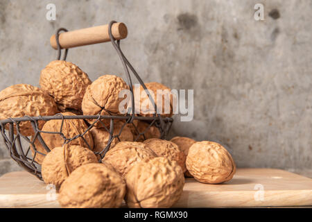 walnut in steel basket on the cement table. Stock Photo