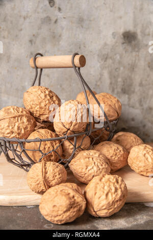 walnut in steel basket on the cement table. Stock Photo
