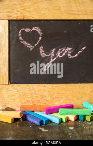 Love you written on blackboard with multi-colored chalk. Stock Photo