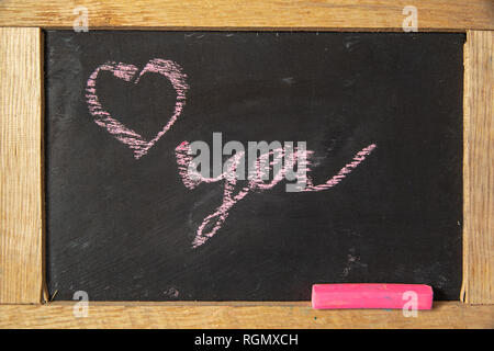 Love you written on blackboard with pink chalk. Stock Photo