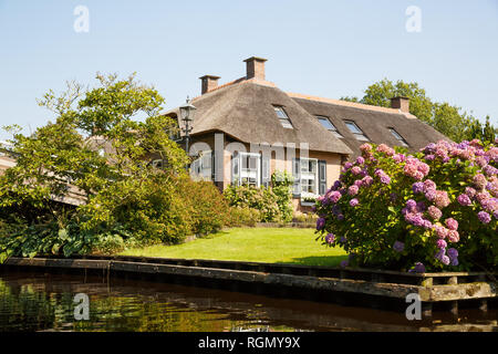 The thatched roof house with beatiful garden in fairy-tale village Giethoorn in The Netherlands. Stock Photo