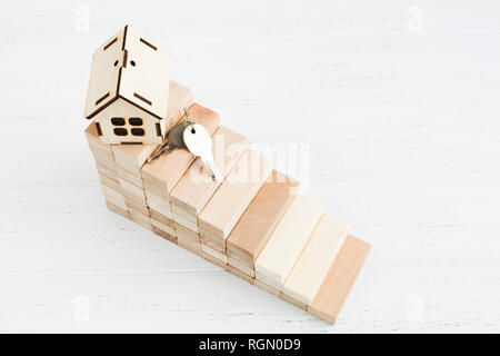 Wooden stairs with house and keys, realty or mortgage concept with copy space Stock Photo