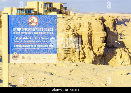 Mitzpe Ramon, Israel - January 18, 2019: Dusty sign calling not to feed the ibex, and landscape of Makhtesh (crater) Ramon, in the Negev Desert, South Stock Photo