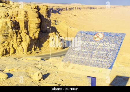 Mitzpe Ramon, Israel - January 18, 2019: Dusty sign calling not to feed the ibex, and landscape of Makhtesh (crater) Ramon, in the Negev Desert, South Stock Photo