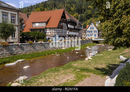 river Schiltach in the town Schiltach, Black Forest, Germany, half timbered houses at the riverside, also Kinzig valley, people relax on the bank Stock Photo