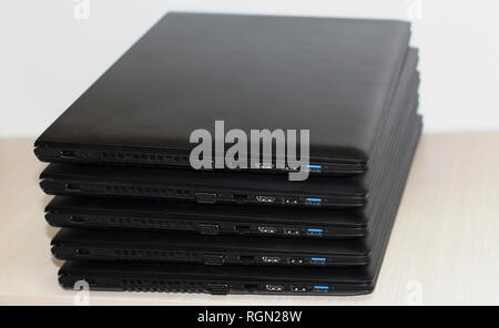 Folded Stack Of Laptops On White Background Stock Photo