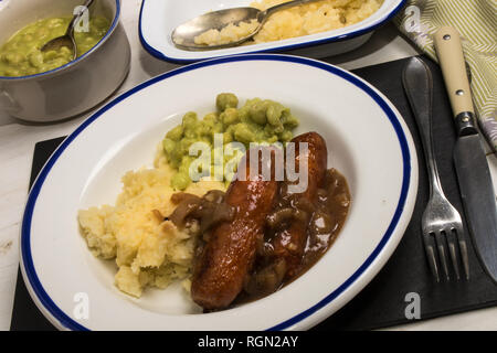 very typical irish dish, mashed potato, onion gravey, grilled sausages and mushy peas Stock Photo