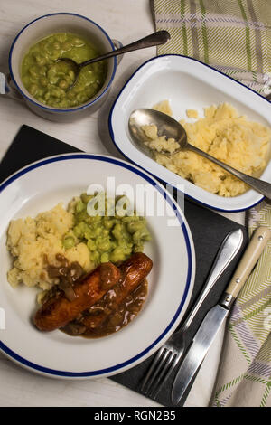 very typical irish dish, mashed potato, onion gravey, grilled sausages and mushy peas Stock Photo