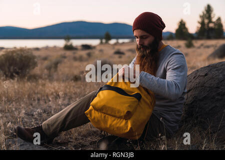 USA, North California, bearded young man having a break on a hiking trip near Lassen Volcanic National Park Stock Photo