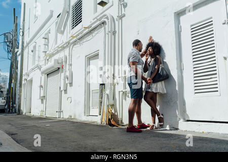 Smiling affectionate young couple standing at building Stock Photo